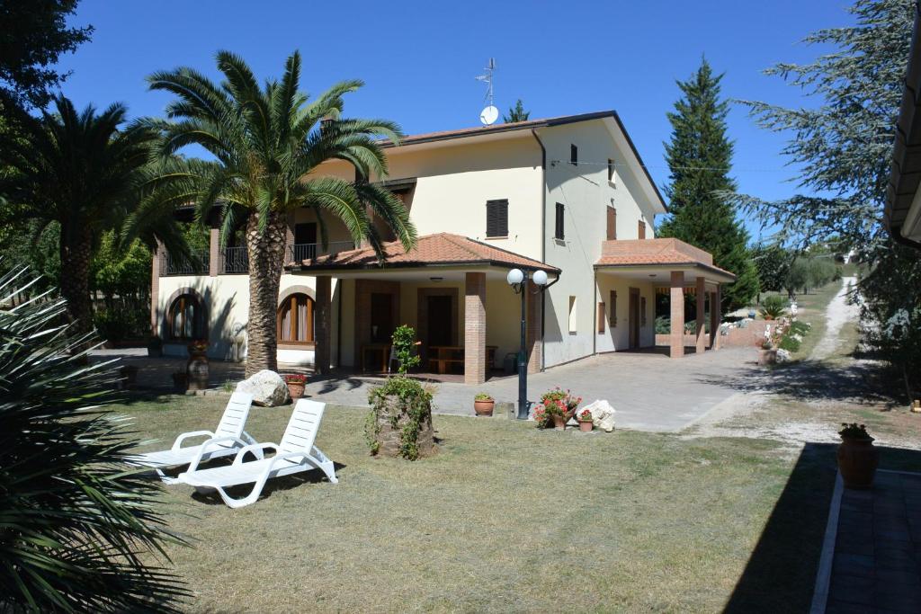 Torano NuovoIl Gheriglio的一座房子,配有两把草坪椅和棕榈树