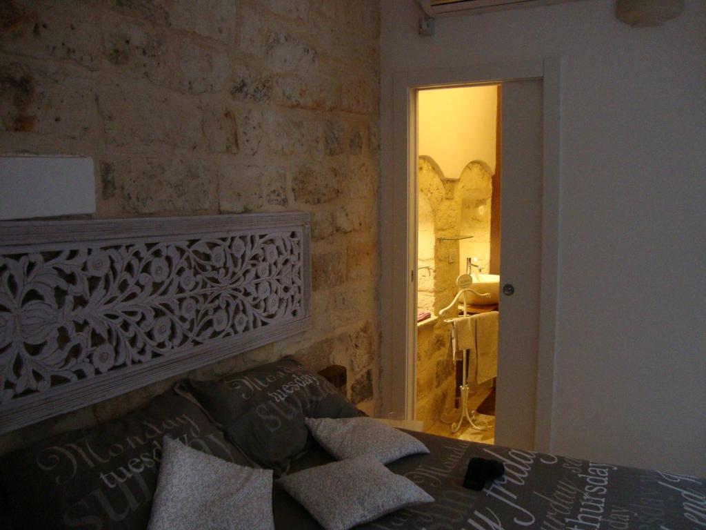 巴里勒尼切住宿加早餐旅馆的一间卧室设有石墙和一张带枕头的床。