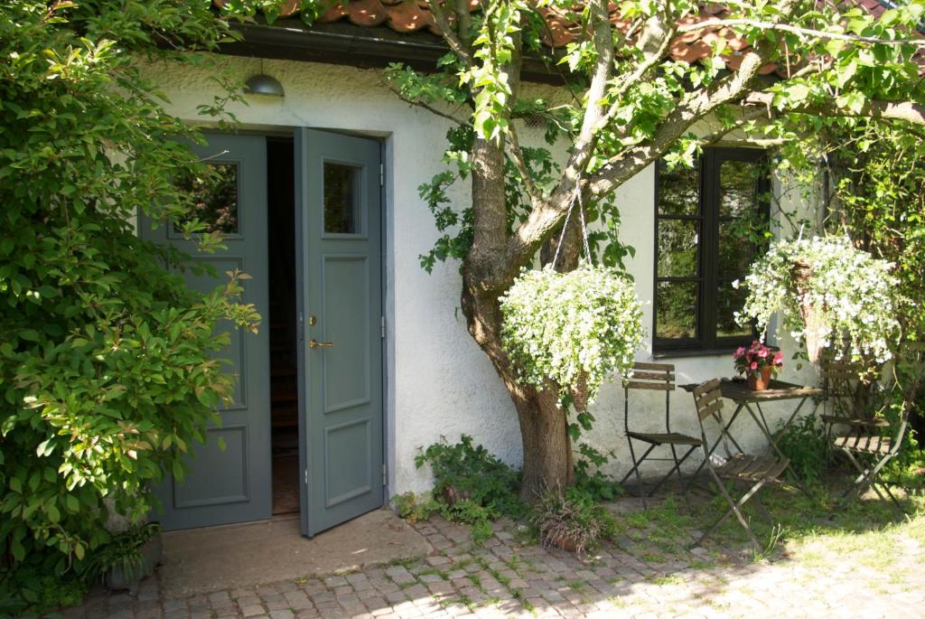 VeberödTrolleberg Bed & Breakfast的一座有蓝色门和一棵树的房子