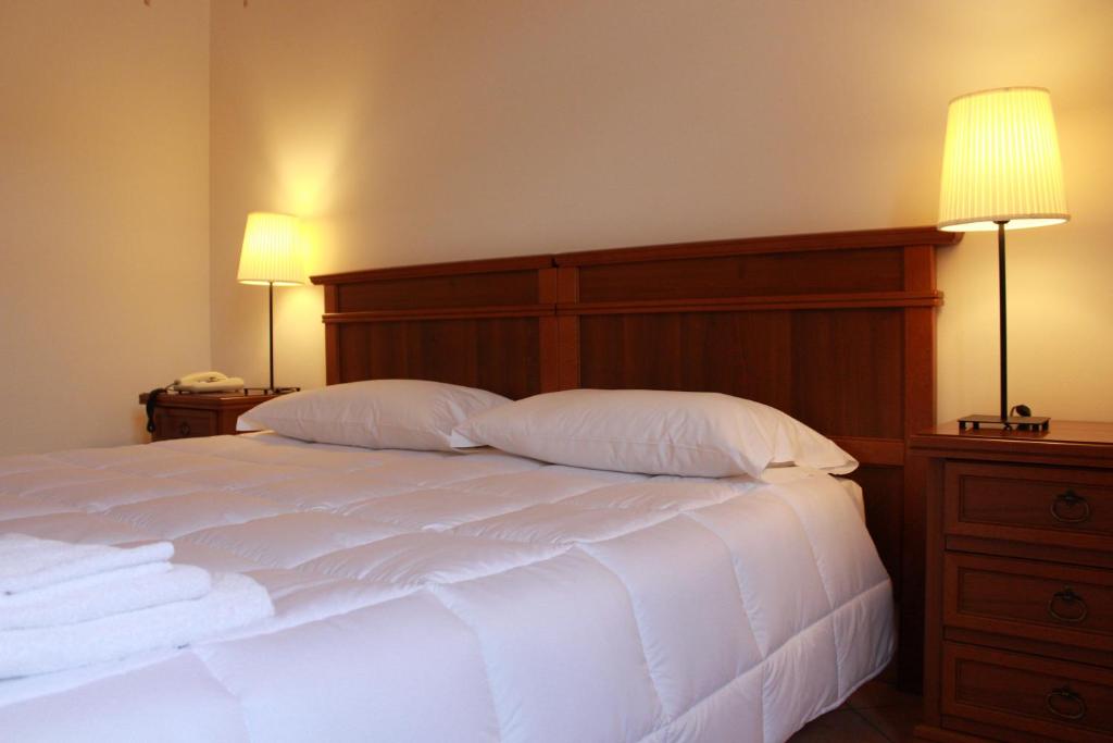 维科福尔泰波尔缇齐酒店的一间卧室配有一张带两个枕头和两个灯的床。