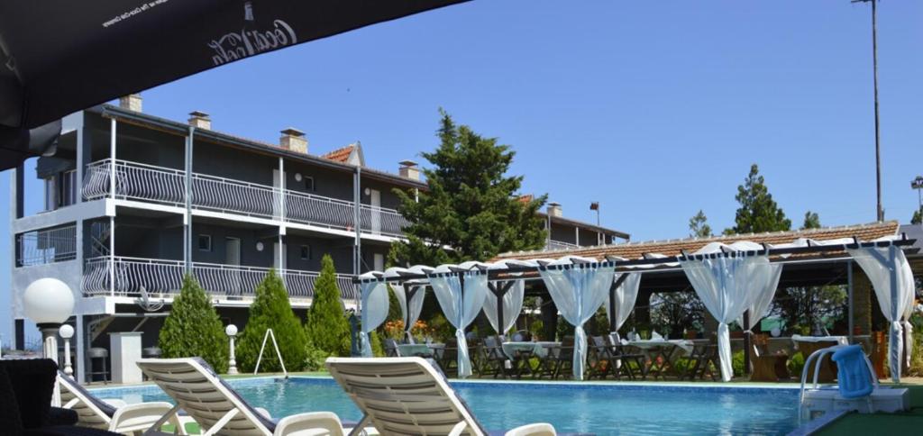 洛泽内茨Complex Exotica的酒店设有带椅子和遮阳伞的游泳池