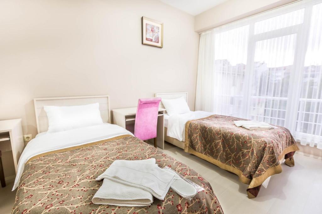 博卢Evren Konukevi Pansiyon的一间卧室设有两张床和窗户。