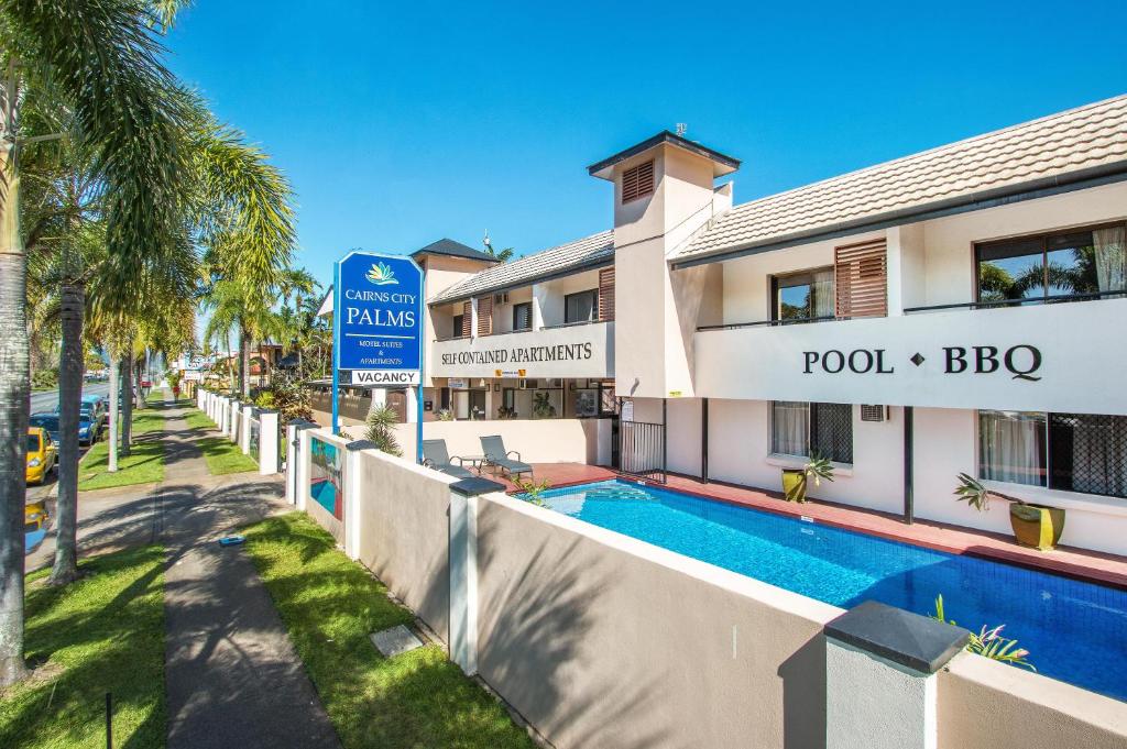 凯恩斯凯恩斯市棕榈汽车旅馆的大楼前设有游泳池的酒店