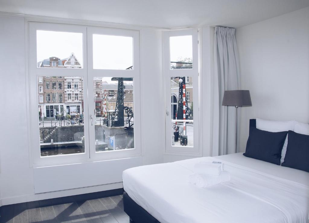 阿姆斯特丹运河住宿加早餐旅馆的卧室配有白色的床和2扇窗户。