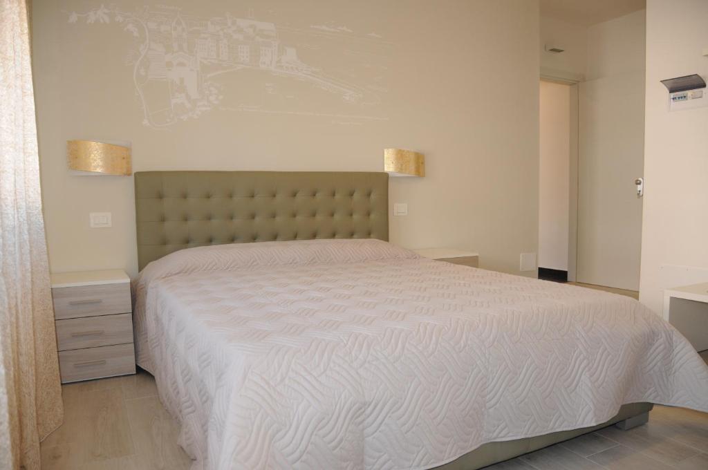 斯培西亚拉佩尔拉住宿加早餐旅馆的一间卧室配有一张带白色床罩的大床