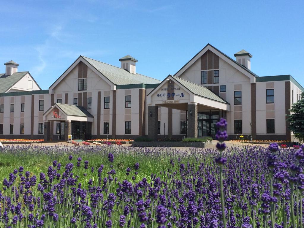 中富良野町富良野拉渔村酒店的一座在前面布满紫色花的建筑