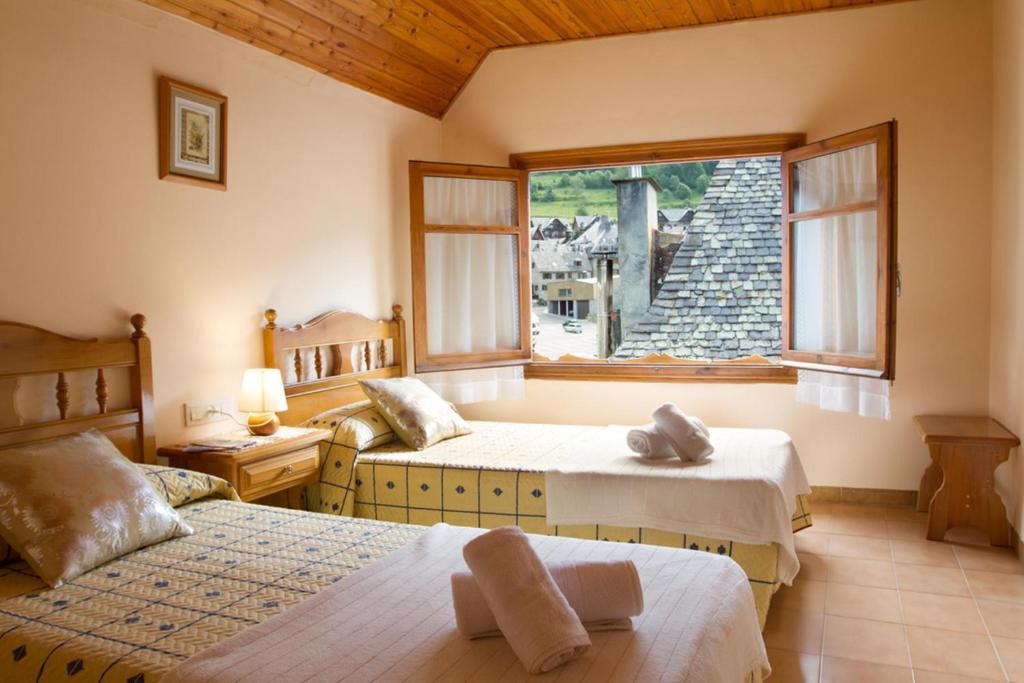 萨拉尔杜Hostal Aiguamog的一间卧室设有两张床和窗户。