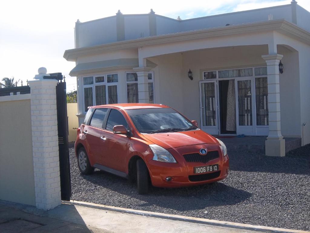 普兰马尼恩Kaz Resident的停在房子前面的一辆红色小汽车