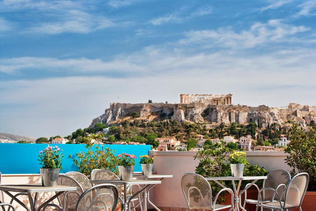 雅典雅典阿利昂酒店的设有带桌椅的餐厅,享有雅典卫城的景致。
