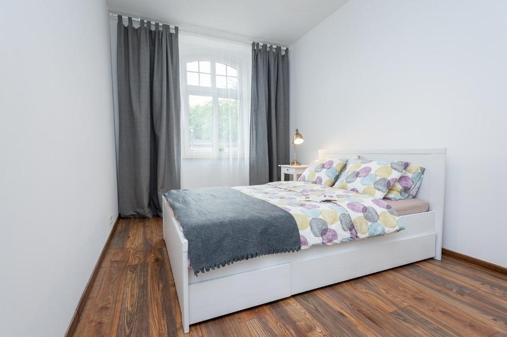 卡托维兹Apartment Zamulkowa Katowice的卧室配有白色的床和窗户。