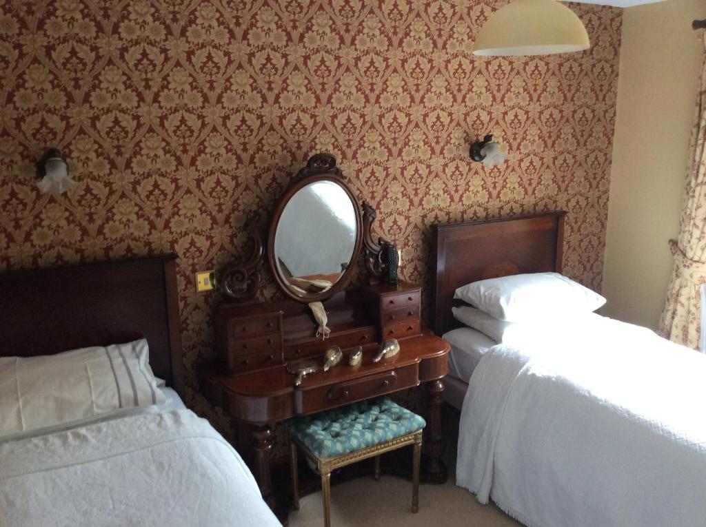 阿瑟斯敦马什米尔旅馆的一间卧室配有两张床、镜子和梳妆台