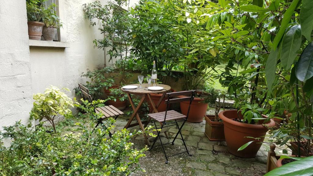 凡尔赛莱斯卡瑞斯酒店的花园里种有植物,配有桌椅