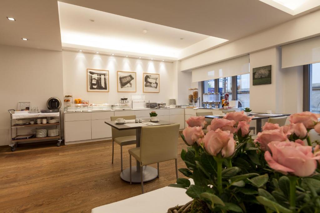 卢森堡西蒙奇尼酒店的厨房配有桌椅和粉红色玫瑰