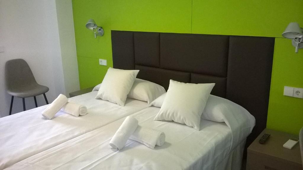 伊维萨镇Huéspedes Sa Font的一间卧室配有白色的床和绿色的墙壁