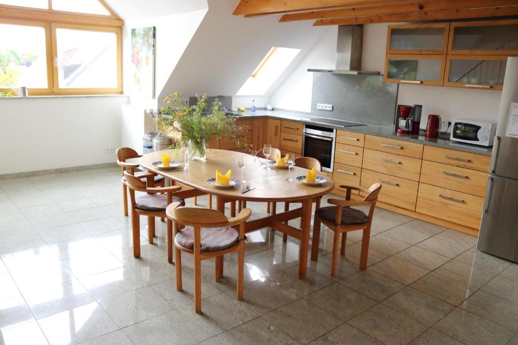 慕尼黑达赫嘎勒瑞公寓的厨房配有木桌和椅子