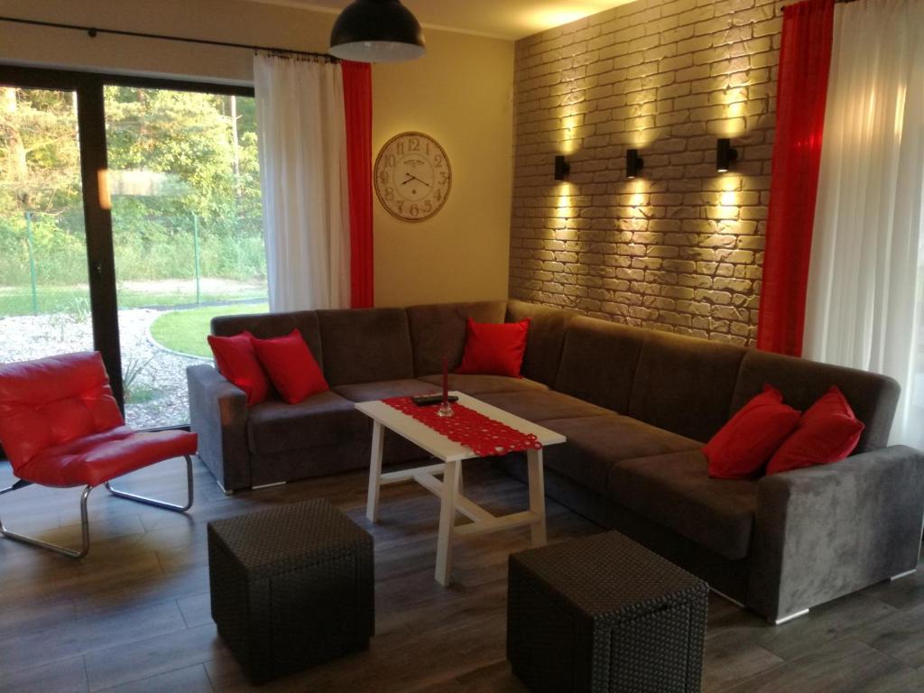 厄尔科Cudodomek SPA w Mrozach Wielkich koło Ełku的客厅配有棕色沙发和红色枕头