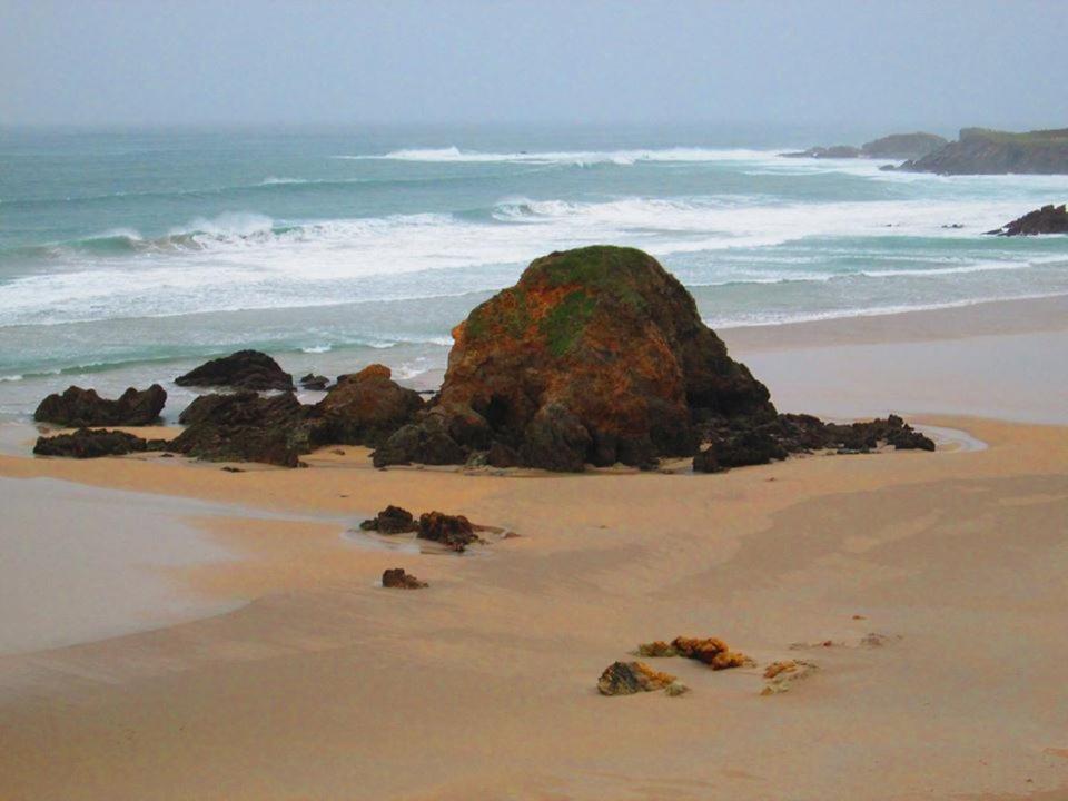 卡斯特罗波尔Hostal Restaurante Parajes的海滩上与海洋交汇的大岩石