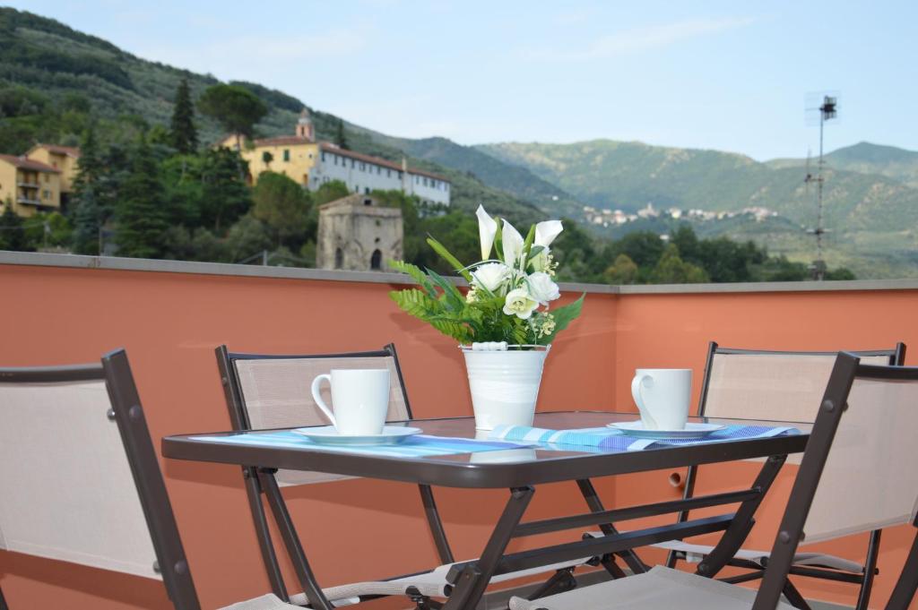 BorgomaroIl Cuore del Borgo - Holiday Home的阳台上的桌椅和花瓶