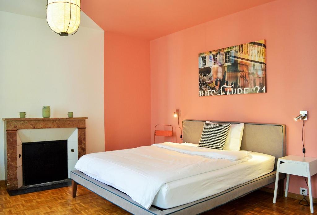 纳沙泰尔路易斯 - 法夫尔21号住宿加早餐旅馆的一间卧室设有橙色墙壁、一张床和一个壁炉