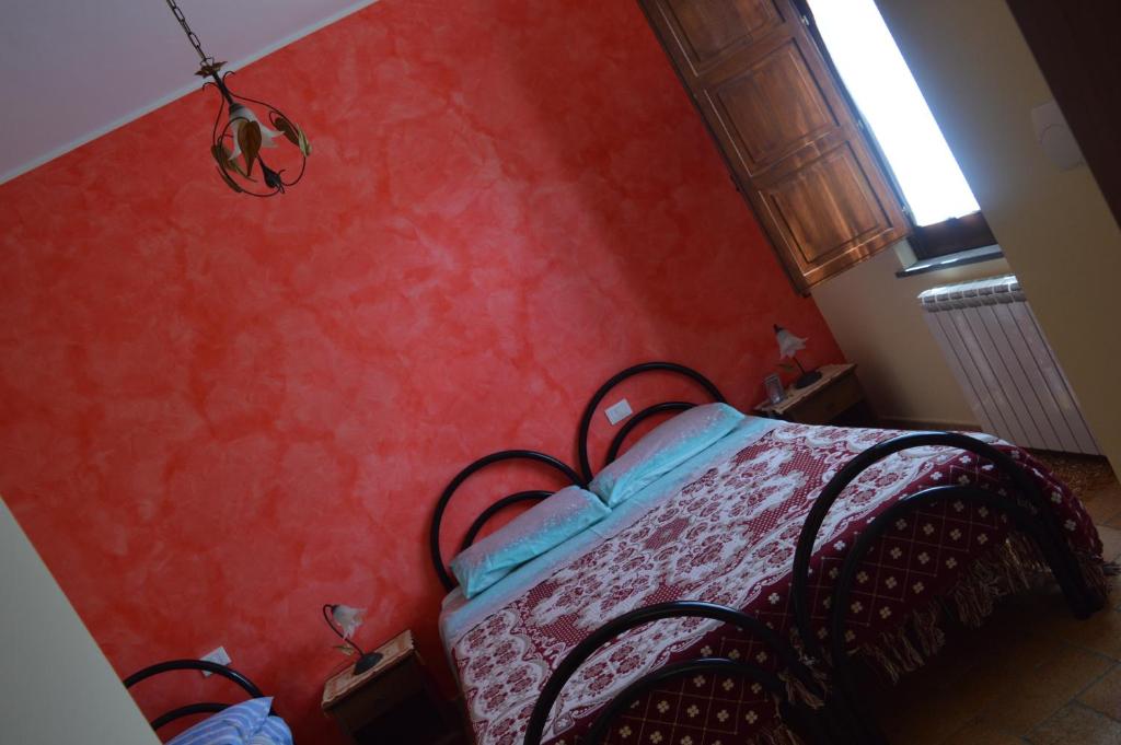 SerrastrettaAgriturismo E Turre的一间卧室配有一张红色墙壁的床