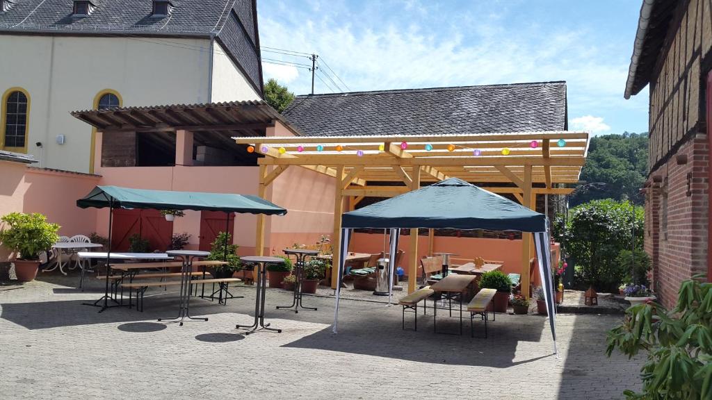 HausenZur Dorfschänke的一个带桌椅和遮阳伞的庭院