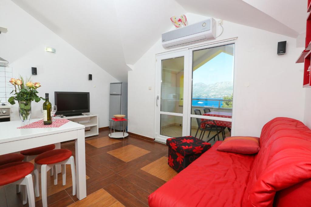 察夫塔特日出公寓的客厅配有红色的沙发和桌子