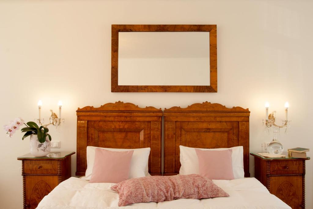 林茨Austria Classic Hotel Wolfinger - Hauptplatz的卧室配有一张床,墙上设有镜子