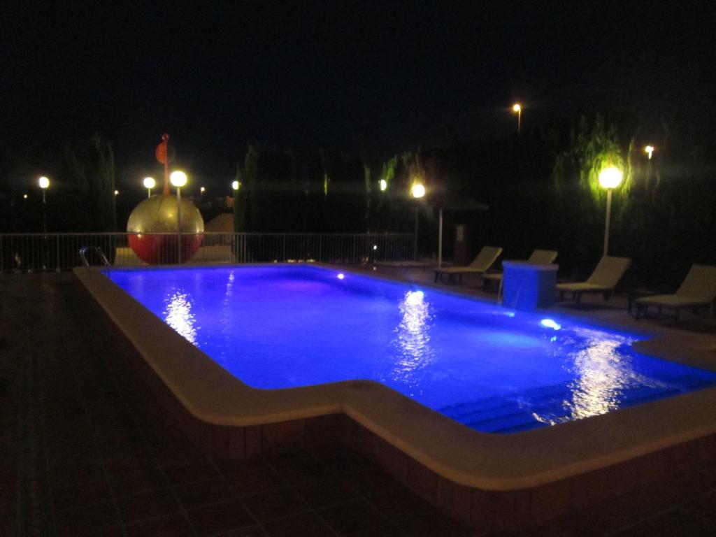 帕洛斯角La Estancia del Rincon的夜间大型游泳池,灯光照亮