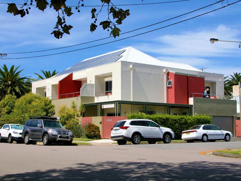 纽卡斯尔朝克棕榈精品住宿加早餐旅馆的停车场内有车辆的建筑物