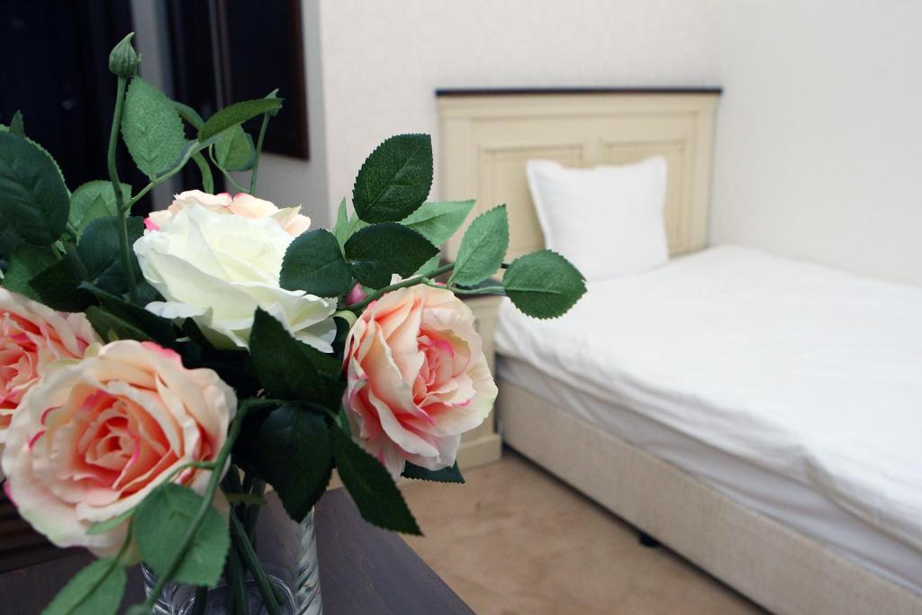 阿普里尔齐帕阿维恩酒店的一间卧室配有一张床和一个玫瑰花瓶