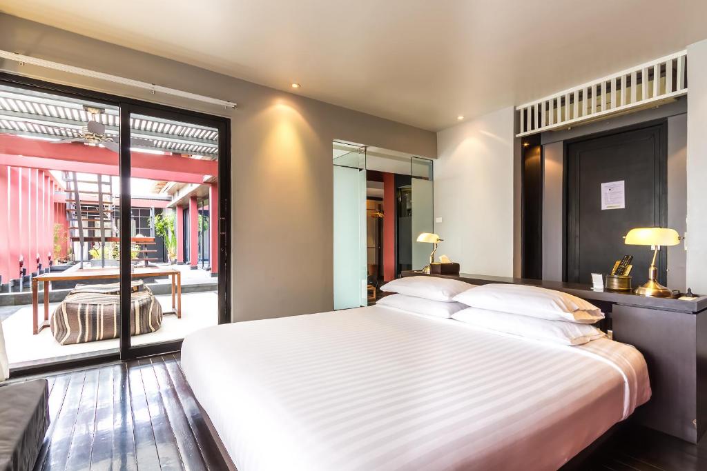 曼谷鲁格楚布民宿酒店的卧室设有一张白色大床和一扇窗户。