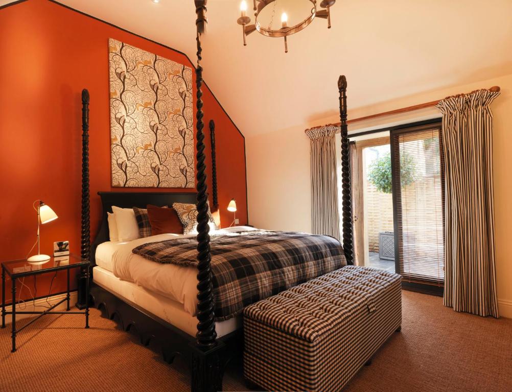 泰特伯里野兔和猎犬酒店的一间卧室设有天蓬床和窗户。
