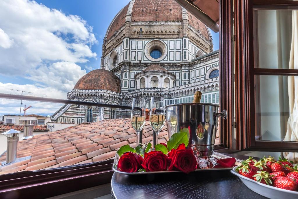 佛罗伦萨佛罗伦萨大教堂酒店的窗户前的玫瑰桌