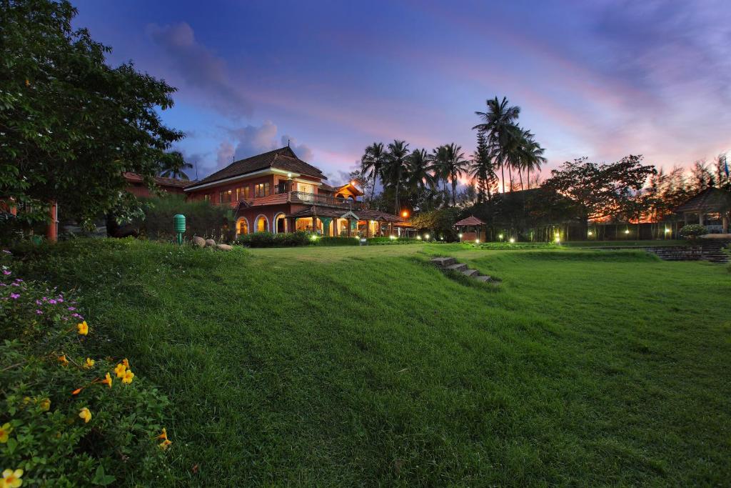 ShoranūrThe River Retreat Heritage Ayurvedic Resort的前面有草坪的大房子