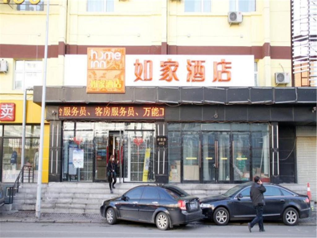 哈尔滨如家快捷酒店哈尔滨道外南极客运站店的两辆汽车停在大楼前