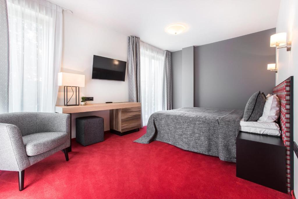 德鲁斯基宁凯辛帕提亚酒店的酒店客房配有一张床、一张桌子和一把椅子。