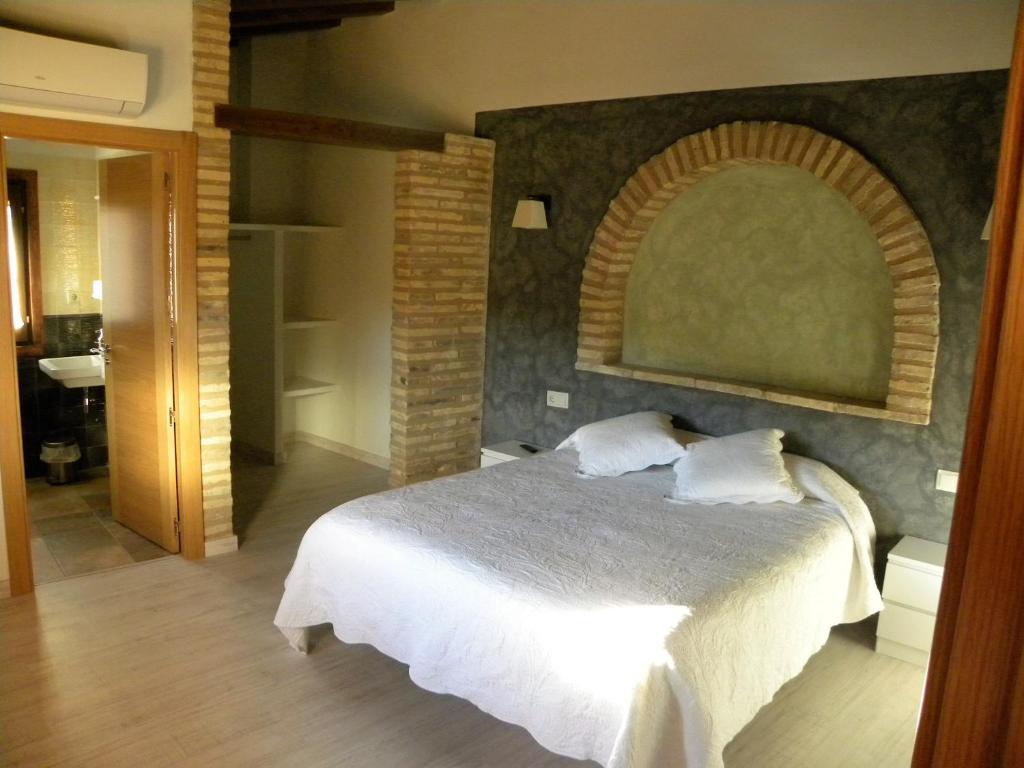 阿尔克萨尔卡萨雅柏内罗旅舍的一间卧室设有一张床和砖墙