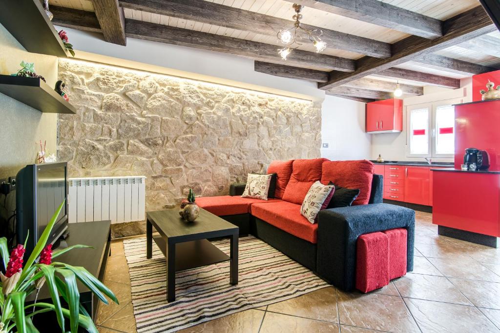 帕拉斯德丽Casa Carla的客厅设有红色的沙发和石墙