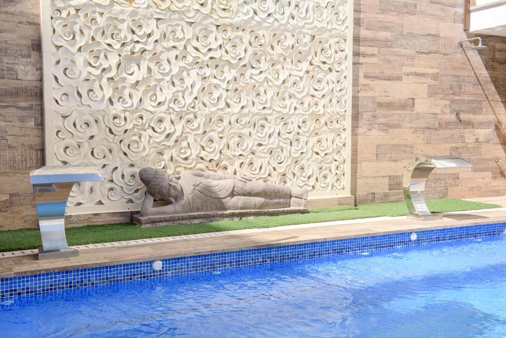圣安东尼奥Hotel Florencio Ibiza的游泳池旁的猫雕像