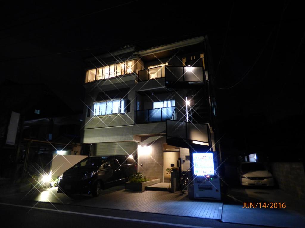 京都最善松室公寓的一座高大的建筑,晚上停在前面