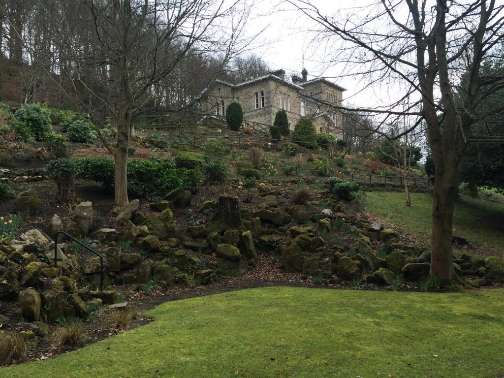 霍伊克曼斯菲尔德之家酒店的一座带岩石的花园,一座房子的背景