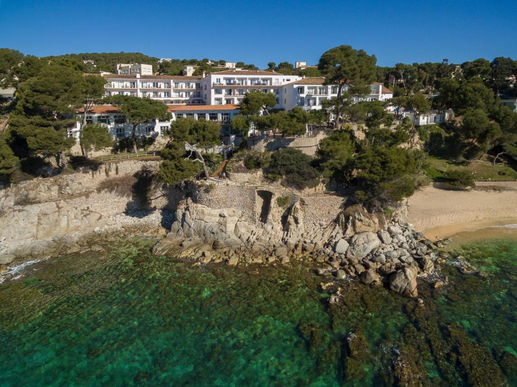 普拉加德阿罗Park Hotel San Jorge & Spa by Escampa Hotels的岩石海岸别墅的空中景观