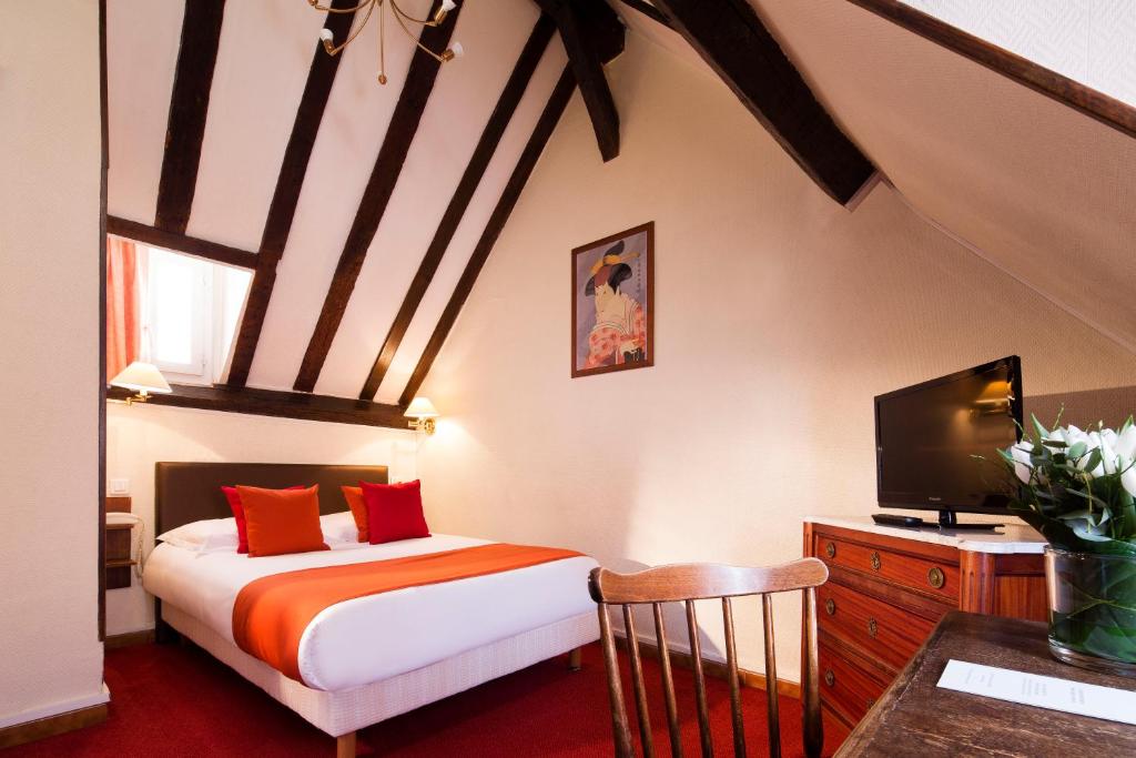 巴黎圣罗奇酒店的一间卧室配有一张床,并在一间客房内配有电视。