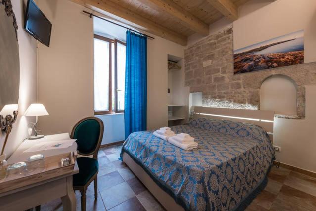 比谢列B&B ANTICO GRANAIO的酒店客房配有一张床、一张书桌和一张书桌。