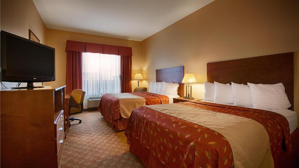 利文斯顿Americas Best Value Inn & Suites-Livingston的酒店客房设有两张床和一台平面电视。