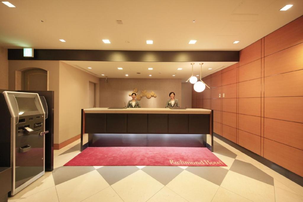 东京东京目白里奇蒙德酒店的两个人坐在一个红色地毯的房间
