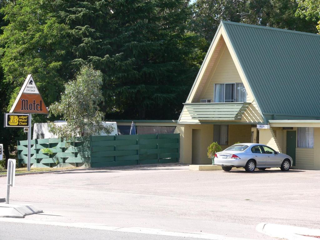 旺加拉塔米勒小屋汽车旅馆的停在房子前面的停车场的汽车