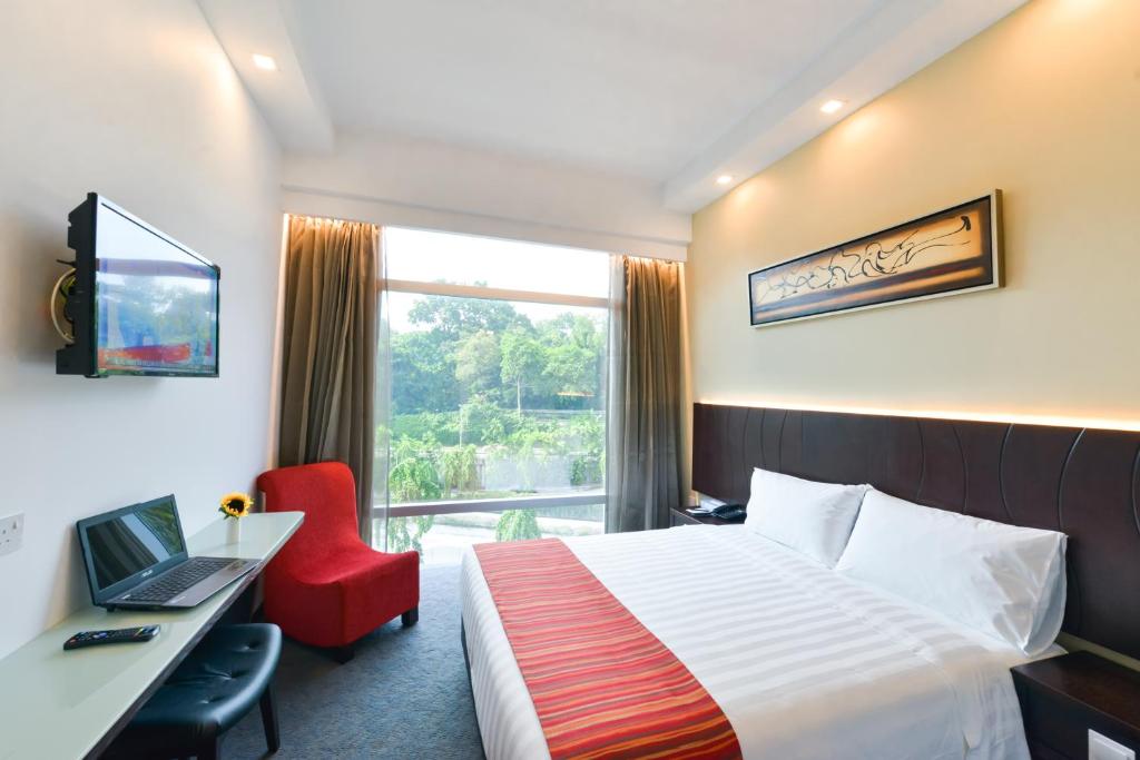 新加坡乌节路大臣酒店的酒店客房配有一张床、一张书桌和一台笔记本电脑