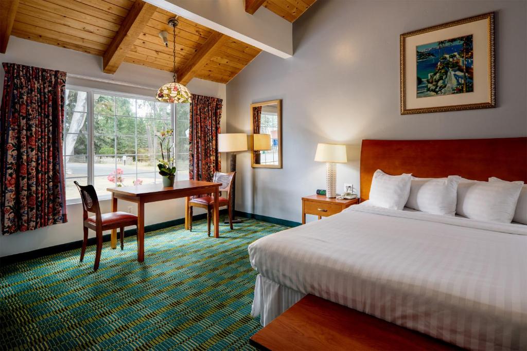 太平洋丛林蝴蝶格罗夫旅馆的配有一张床、一张桌子和一张桌子的酒店客房