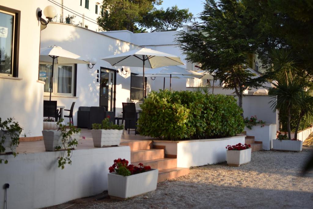 维耶斯泰阿拉杰斯特假日俱乐部公寓式酒店 的白色的房子,有植物和雨伞